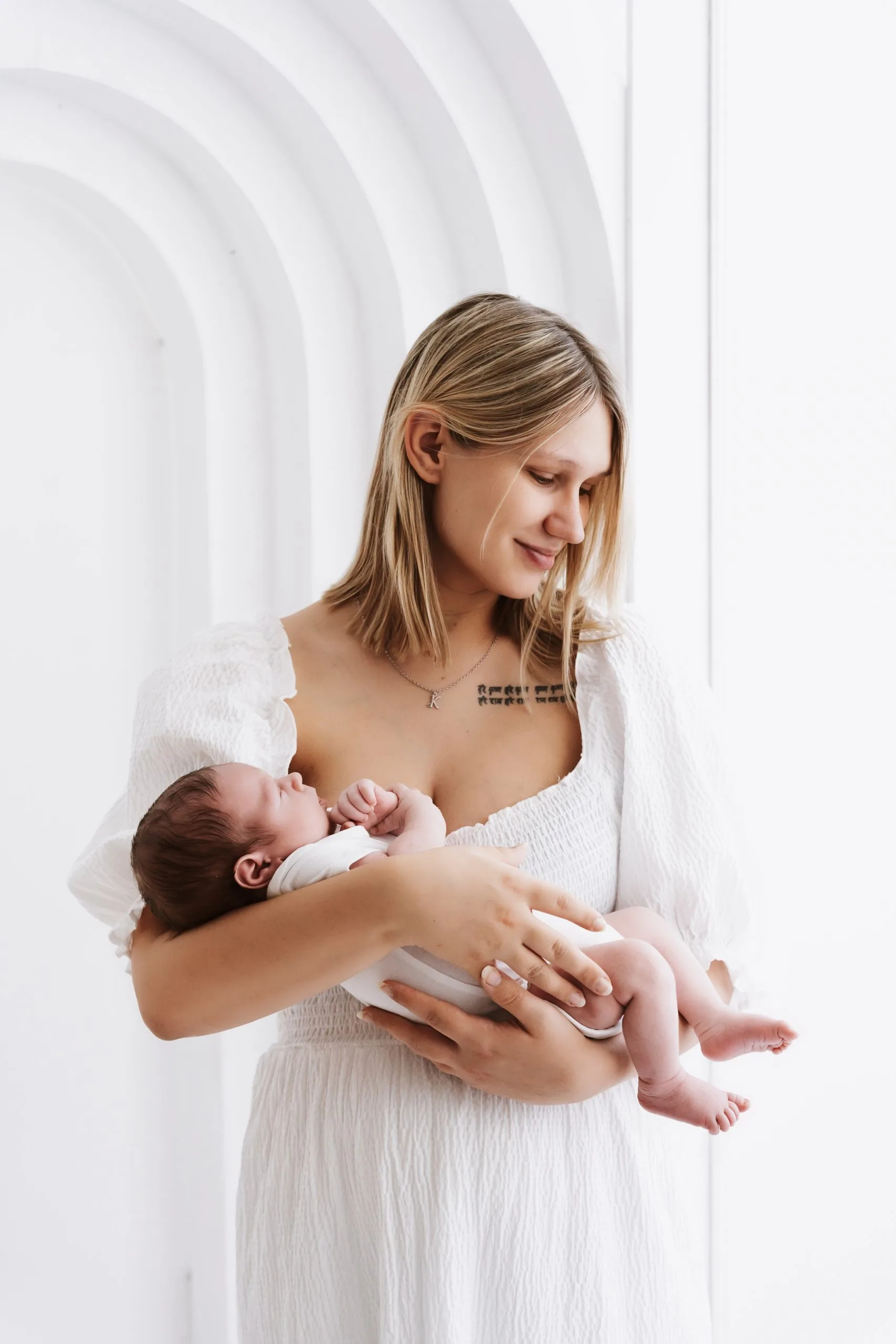 "Mama nežno drži svojega dojenčka v naročju."