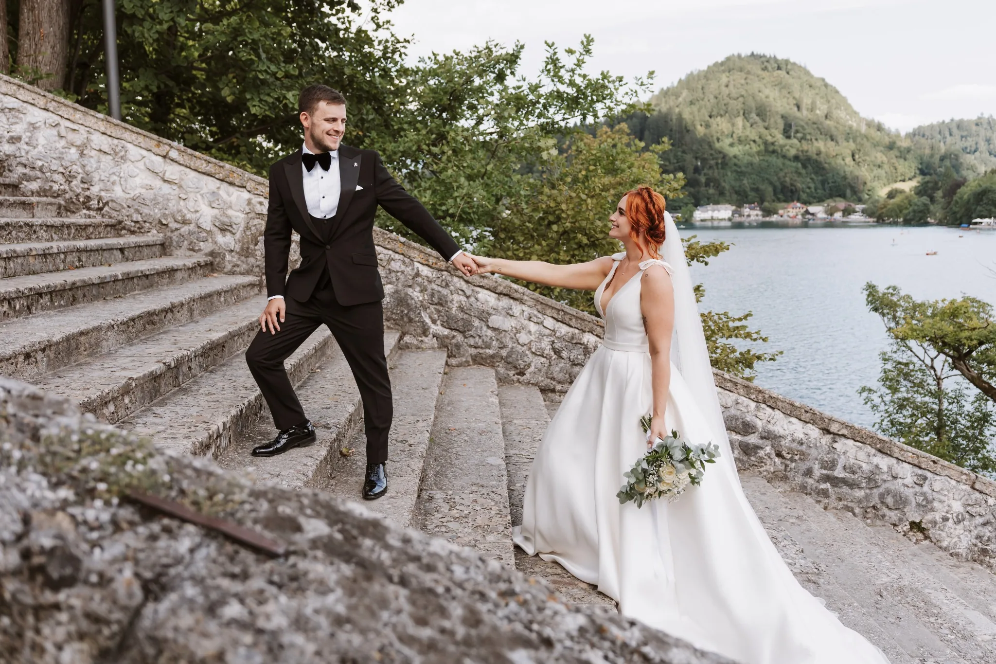 Wedding couple on stone steps beside Lake Bled