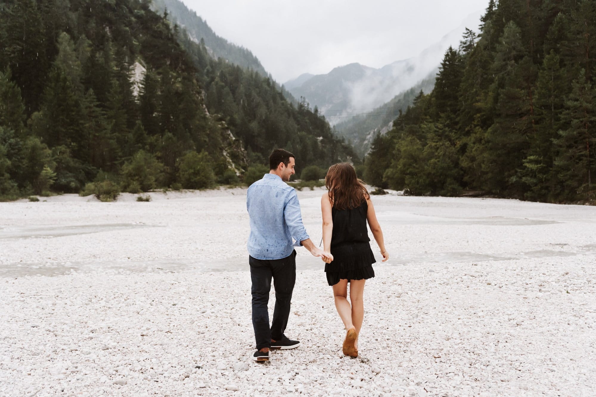 Engaged couple walking through the alpine landscape near Lake Jasna in Kranjska Gora